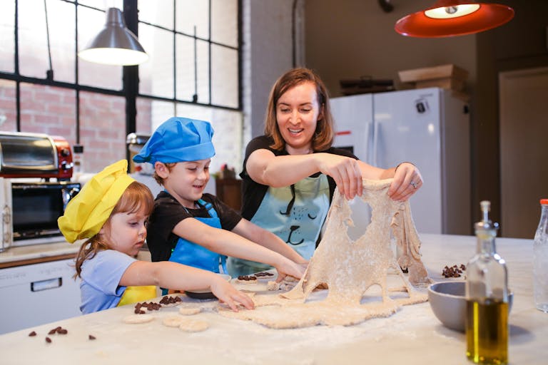 A family enjoys baking chocolate chip cookies together in a bright kitchen.